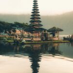 A serene view of Ulun Danu Beratan Temple with reflections on the water at sunrise, Bali.