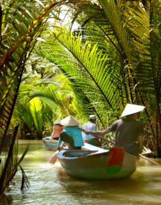 Experience a serene riverboat journey through lush tropical palms in Ho Chi Minh City, Vietnam.