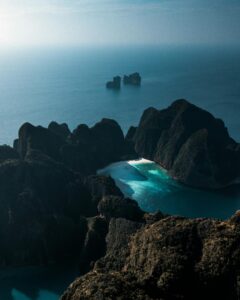 Stunning aerial view of rocky cliffs and turquoise waters in Krabi, Thailand, showcasing nature's beauty.