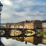 A breathtaking view of Florence's architecture reflecting in the river at dusk, capturing the vibrant essence of Italy.